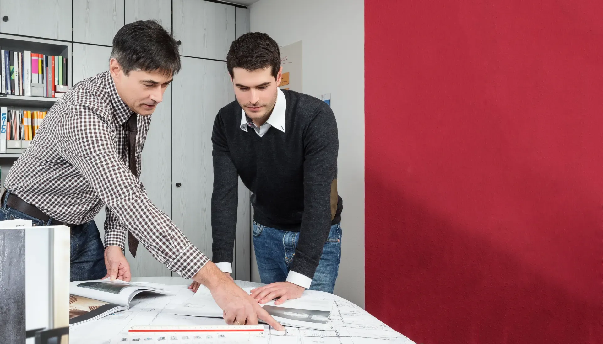 Josef und Markus Pfeuffer besprechen einen Elektroplan am Besprechungstisch